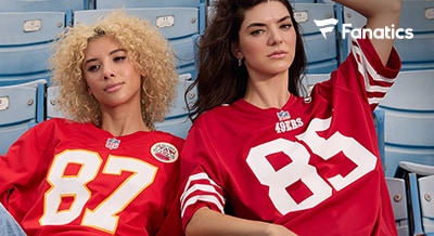 two woman in bleachers wearing football jerseys