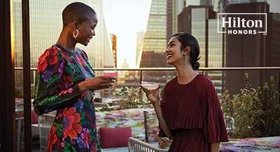 two women enjoying a cocktail on a hotel rooftop