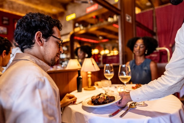 couple dining out at a restaurant eating steak and drinking wine