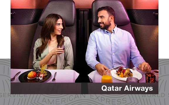 A couple enjoying a meal on a Qatar Airways flight.