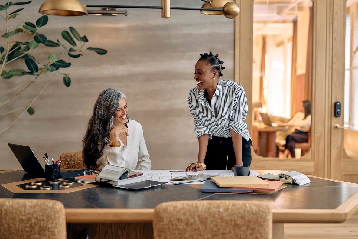 Two colleagues collaborating on laptop in modern office