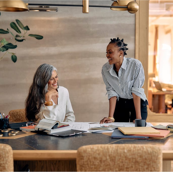 Two colleagues collaborating on laptop in modern office