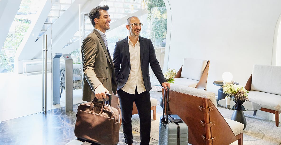 Business person with luggage using phone in airport terminal