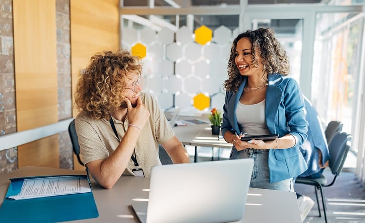People smiling while collaborating in an office setting