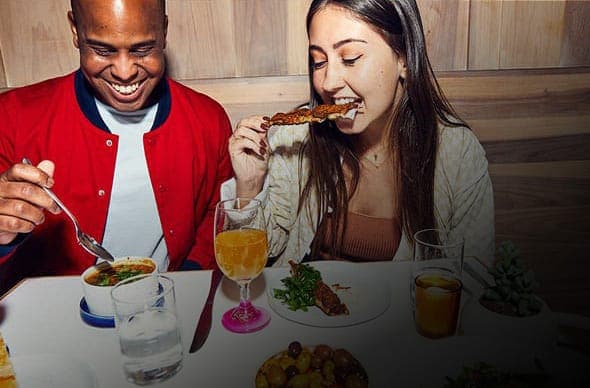 People enjoying dinner and drinks with the RESY logo