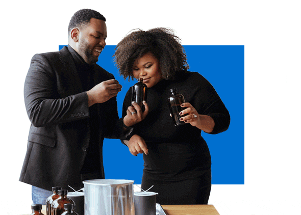 Fay and Chris Breedlove, African American business owners, standing in front of their scent compounds.
Mariana Russo Chambers, Latina small business owner, creating jewelry at her desk.