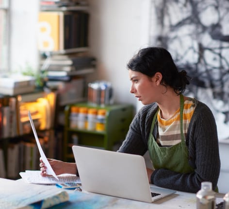 Woman sitting and looking at a paper in hand