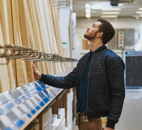 Man browsing wood beams at store