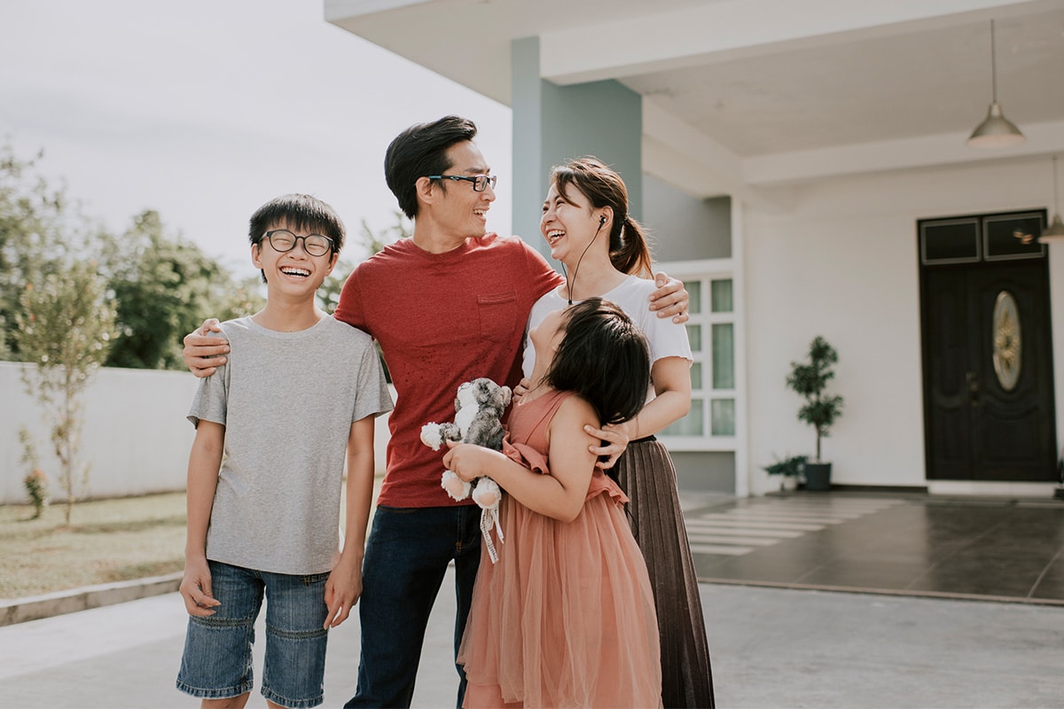 A family standing before their home, exuding warmth and unity