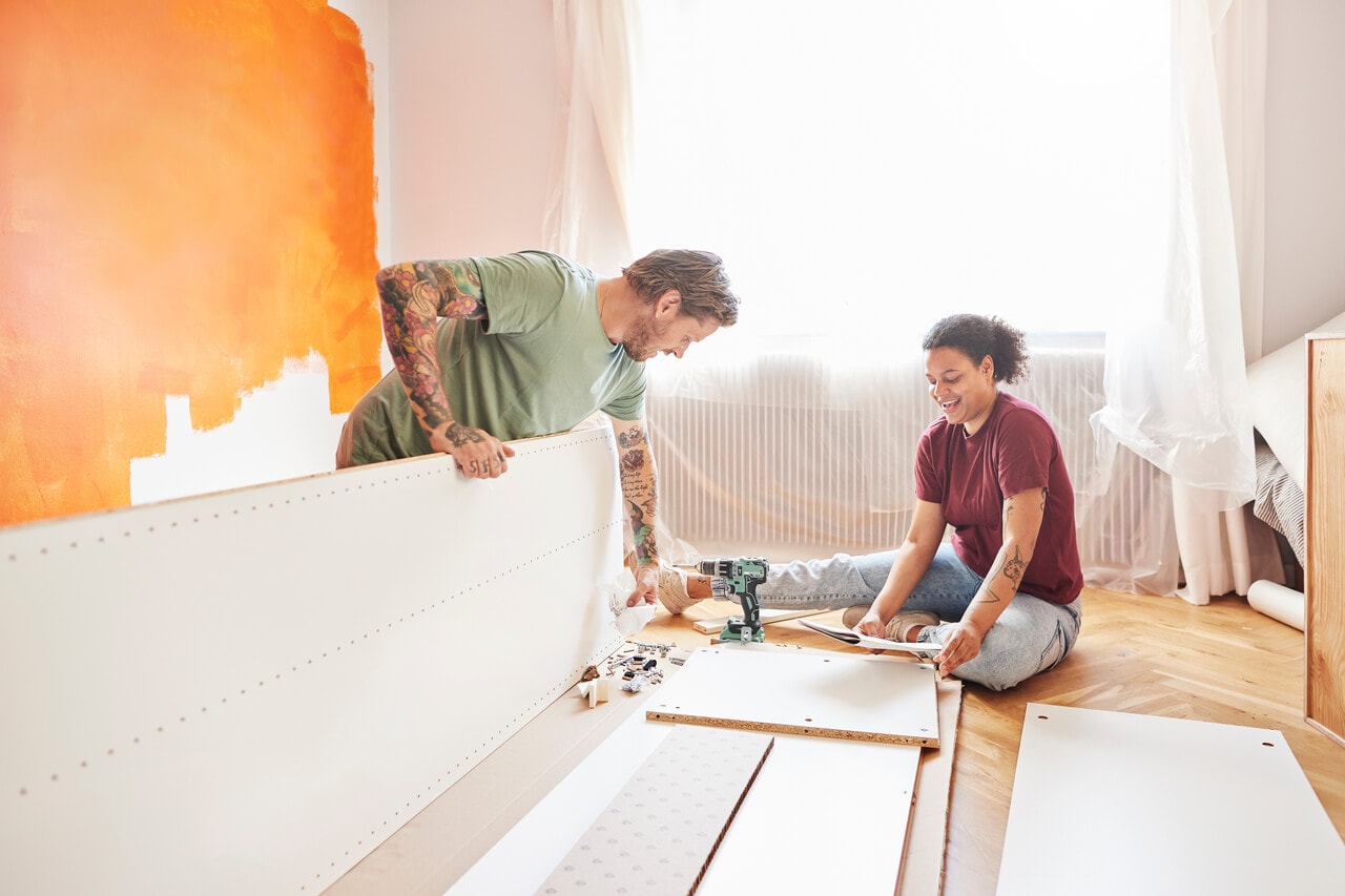 A couple working on home improvement by painting their apartment