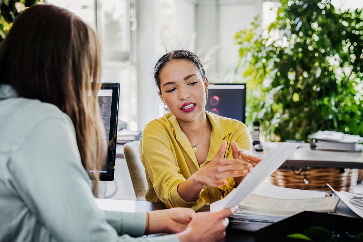 A homebuyer reviewing documents on closing costs with a real estate agent