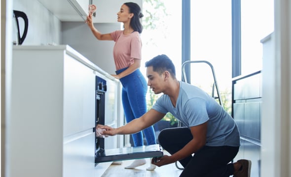 Man and woman cleaning kitchen