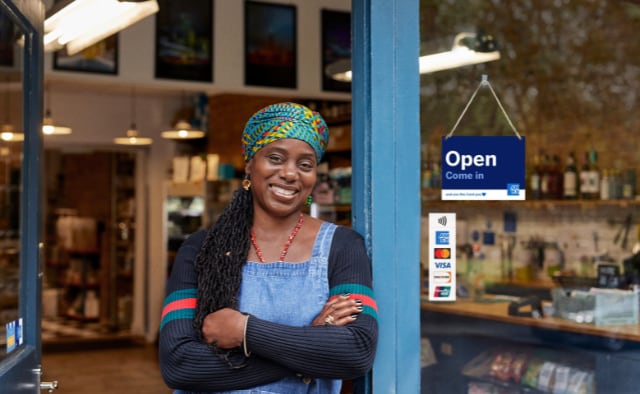 Business owner outside store with POP materials