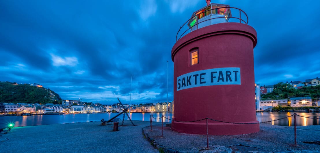 Ein eingeschossiger roter Leuchtturm direkt an der Mole der norwegischen Hafenstadt Ålesund