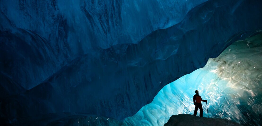 Ein Mensch mit Teleskopstock in einer gigantischen Eishöhle im kanadischen Ort Whistler