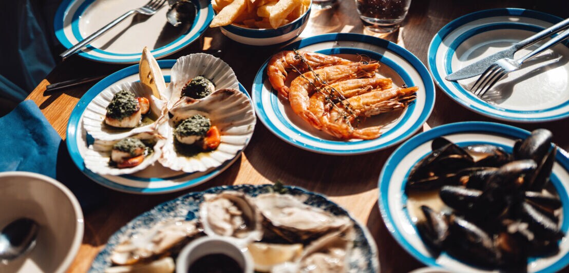 Verschiedene Meeresfrüchte auf kleinen Tellern auf einem Tisch in einem Restaurant.