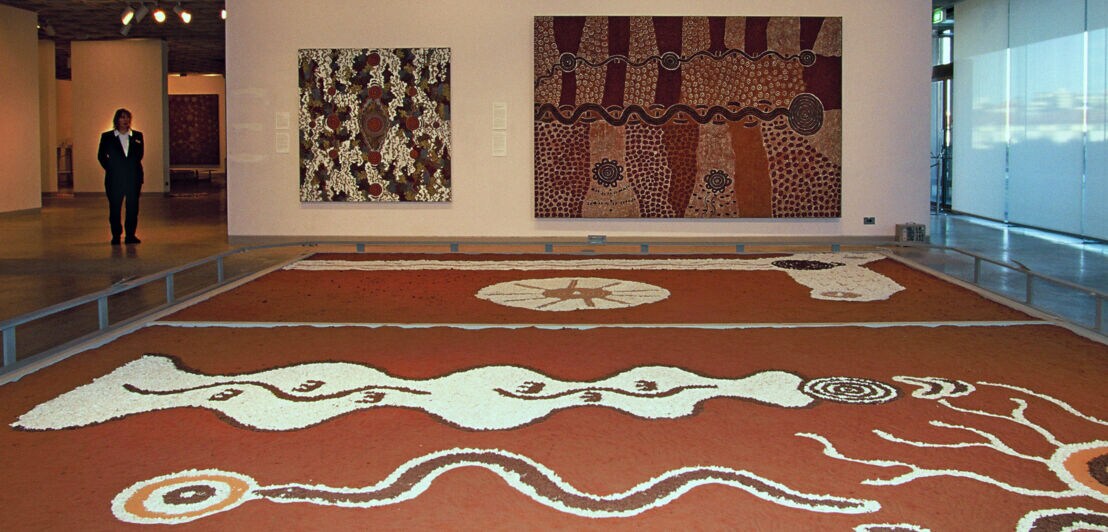 Ausstellungsraum mit Aboriginal Art Exponaten in Brauntönen.