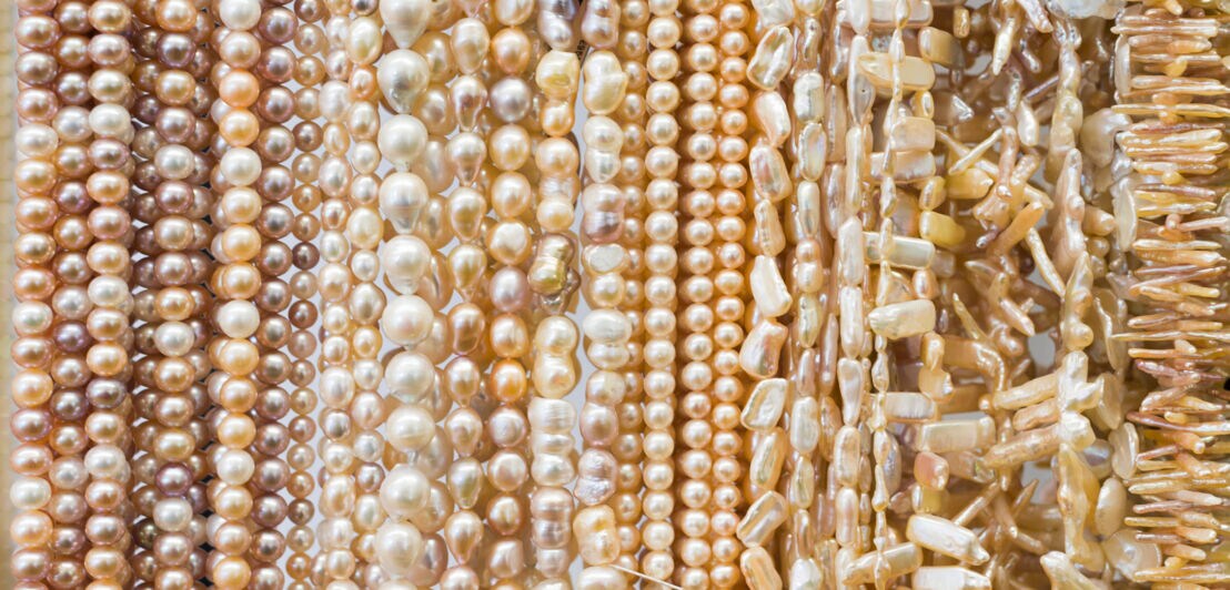 Viele Perlenketten mit unterschiedlichen Perlen dicht nebeneinander