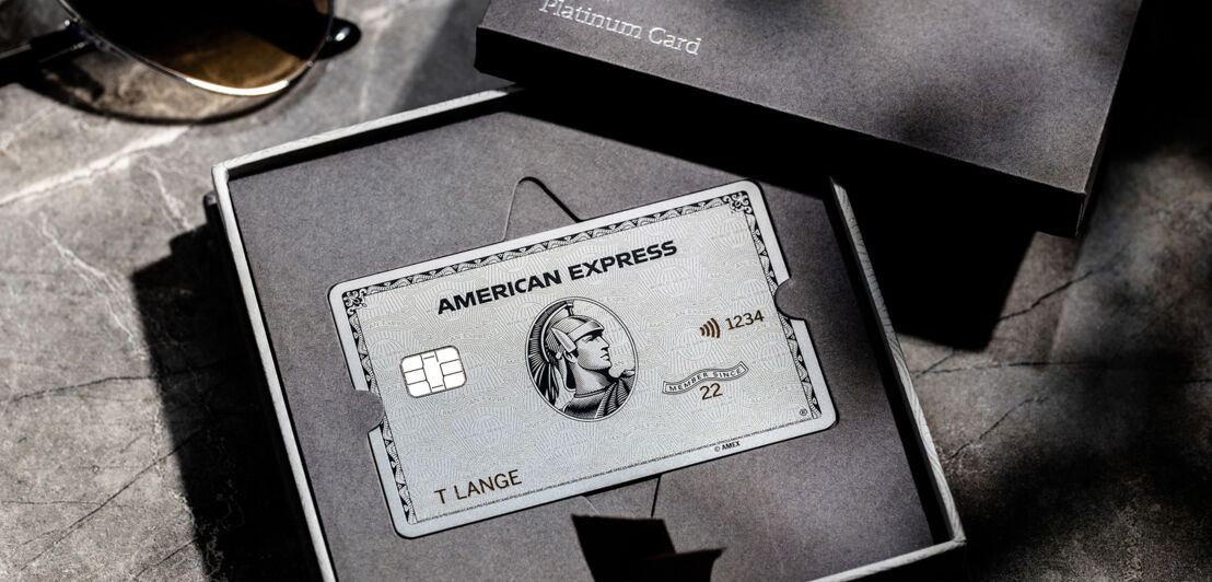 Eine silberne Platinum Kreditkarte von American Express in einer Präsentationsbox aus grauer Kartonage.