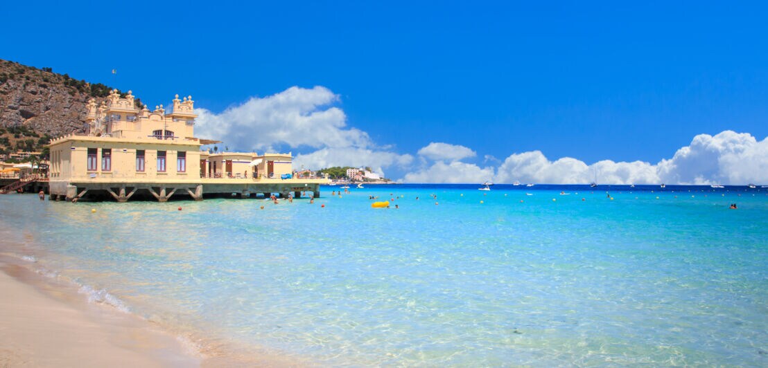 Der weiße Sandstrand von Mondello mit dem hübsch verzierten Kurhaus im Hintergrund.