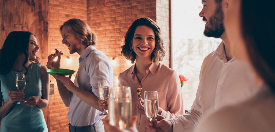 Eine Gruppe entspannter Frauen und Männer während einer Firmenfeier