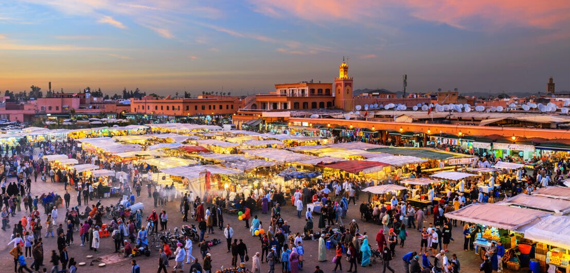 Belebter Marktplatz im Zentrum Marrakeschs am Abend.