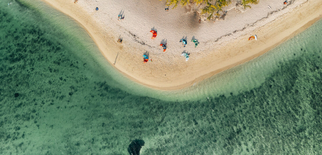 Aufsicht auf den Strand von Le Morne mit bunten Kitesurf-Drachen