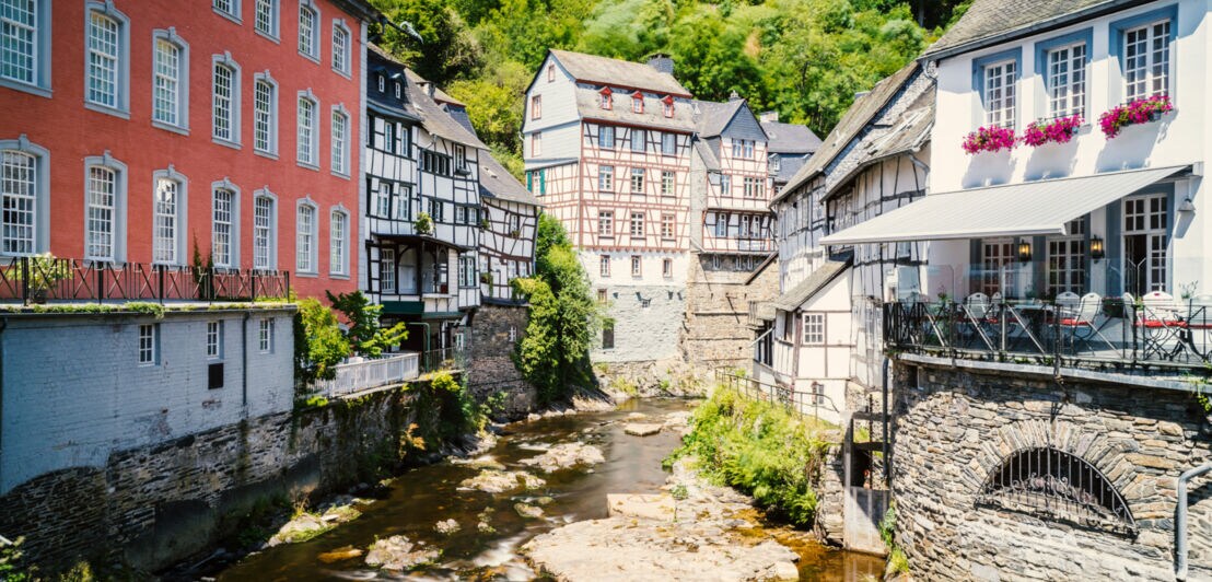 Blick auf Fachwerkhäuser an einem kleinen Fluss in der historischen Altstadt von Monschau.