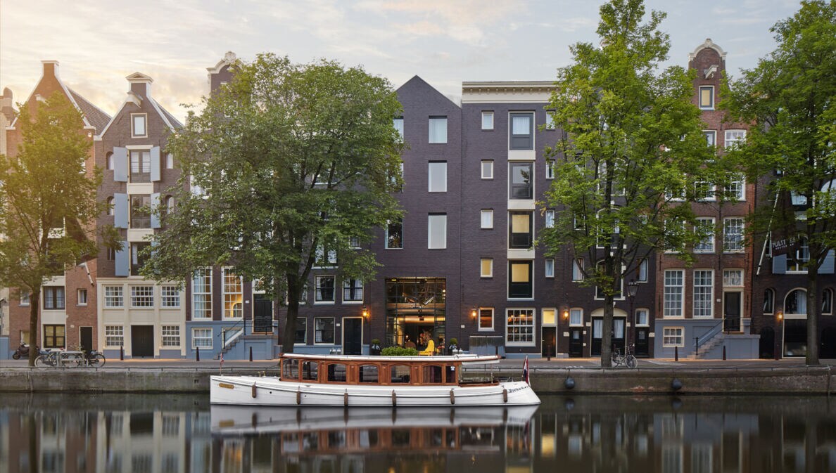 Hotelkomplex aus restaurierten Grachtenhäuser am Kanal mit Boot.
