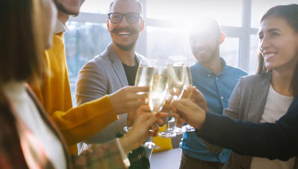 Business people celebrate with glasses of champagne in the offic