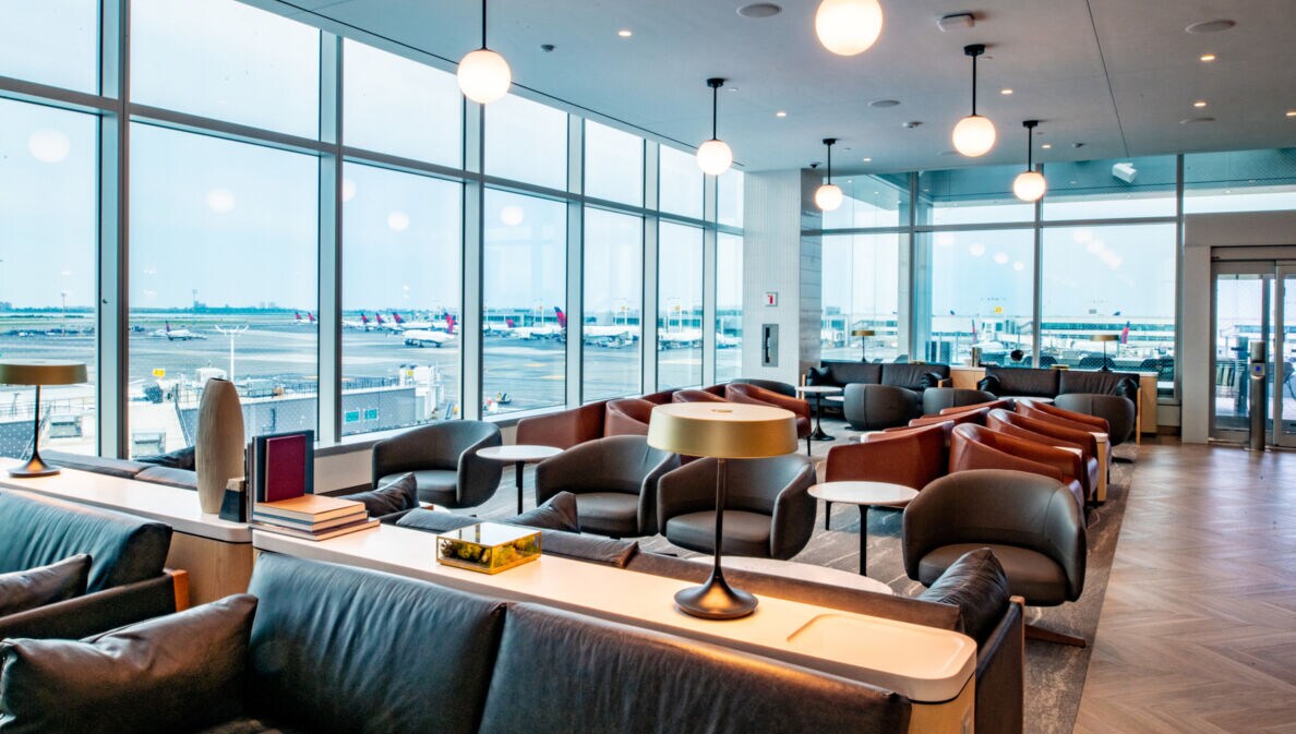 Helle und moderne Flughafenlounge mit Blick aufs Rollfeld durch Panoramafenster.