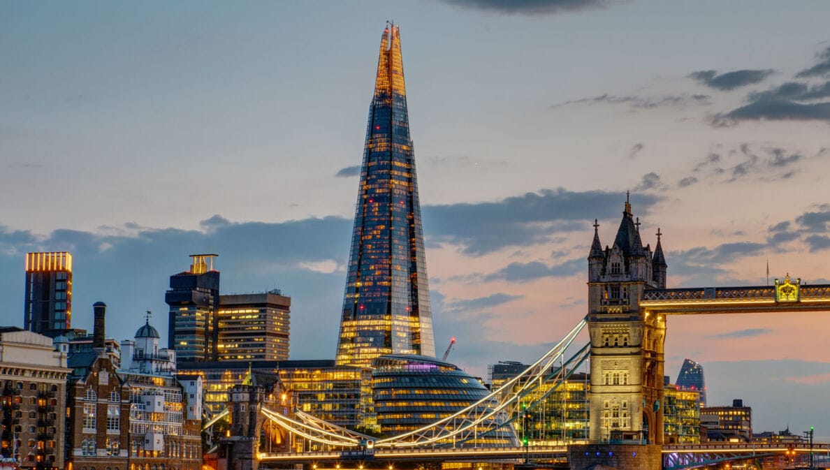Beleuchtete Londoner Skyline mit Wolkenkratzer The Shard und Tower Bridge am Abend.