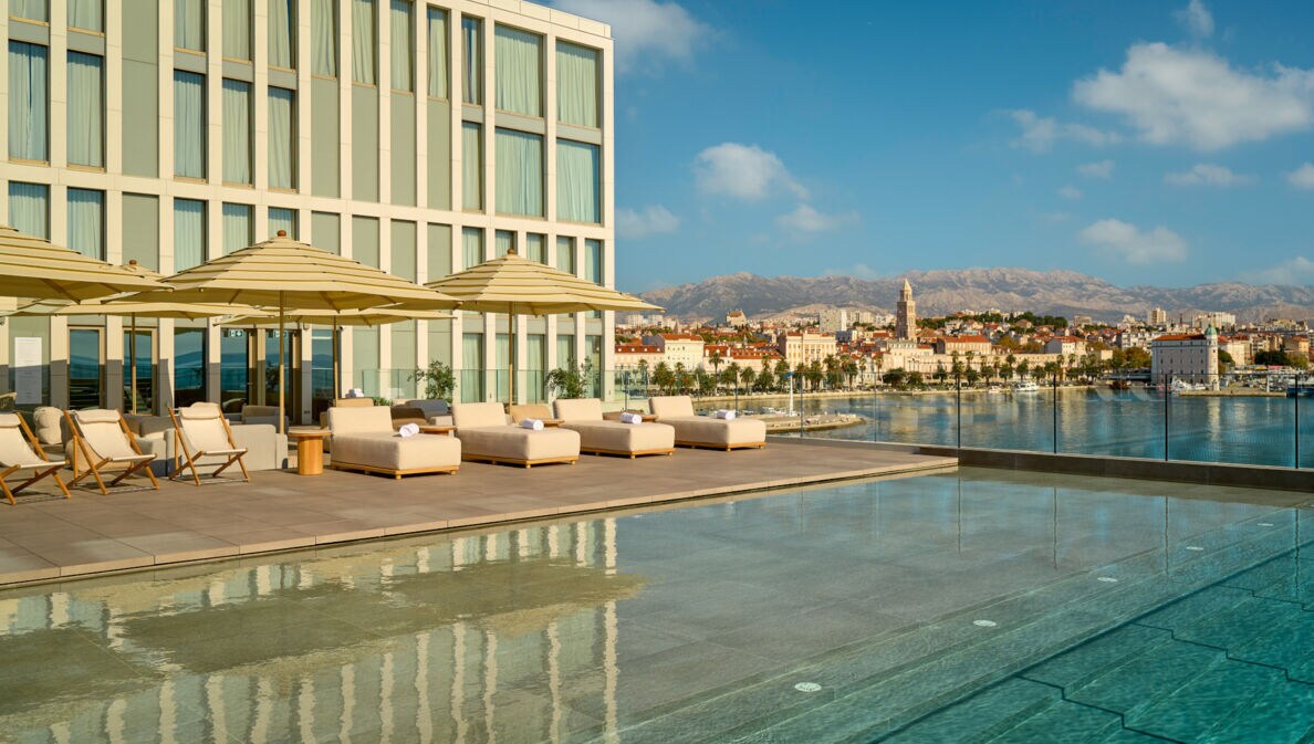 Großer Außenpool mit Liegestühlen auf der Terrasse des Hotel Ambasador in Split.