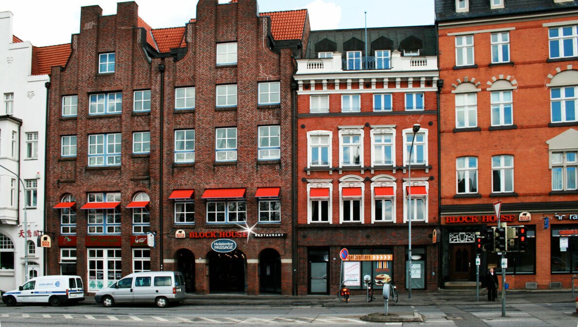 Häuserfront mit Giebelhäusern aus Rotsteinklinker mit Block House Schriftzug.