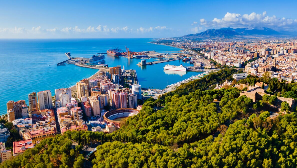 Luftaufnahme von Málaga mit Meer und Bergen im Hintergrund.