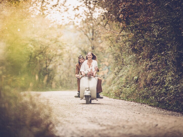 Ein junges Pärchen auf einer alten Vespa