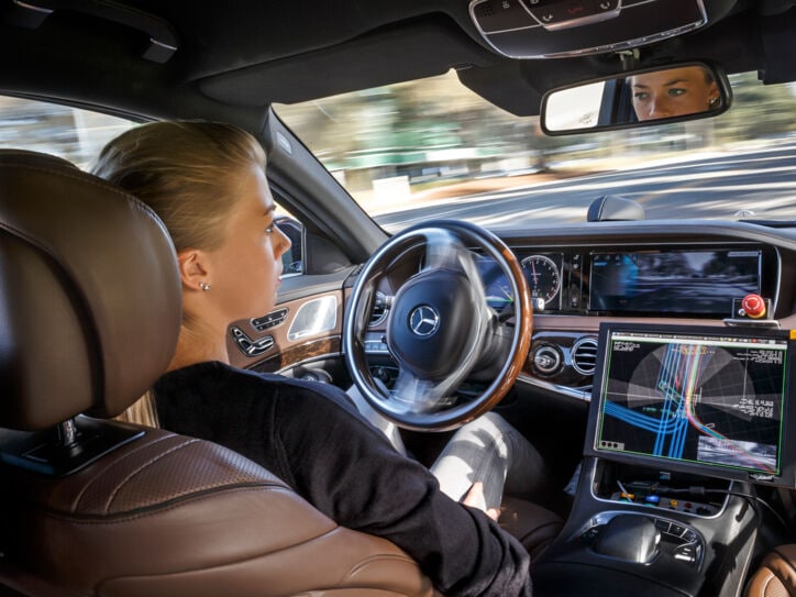 Blick in das Cockpit eines Pkw. Die Hände der Fahrerin sind nicht am Lenkrad