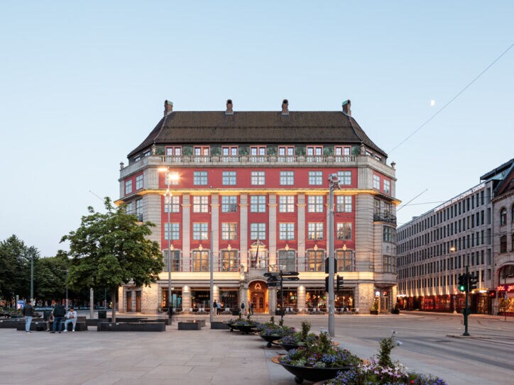 Prächtiges, beleuchtetes rotes Gebäude, davor ein großer Platz