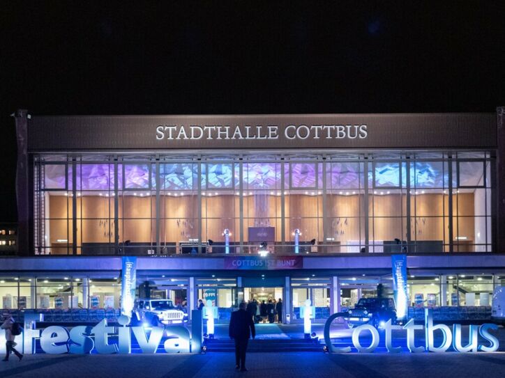 Nachtaufnahme einer Veranstaltungshalle beim Filmfestival Cottbus