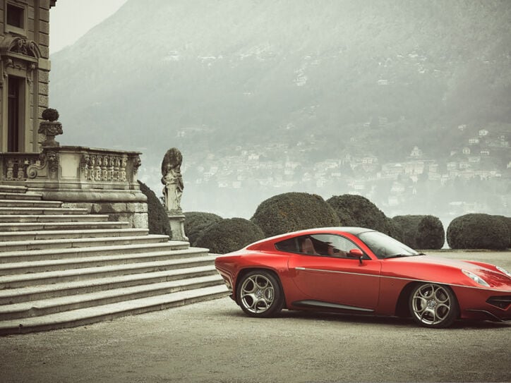 Ein rotes Auto vor der Treppe eines herrschaftlichen Hauses