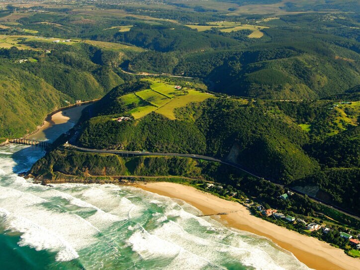 Luftaufnahme der Garden Route, die durch grüne Wälder entlang der Küste führt