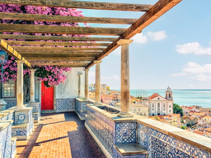 Terrasse mit portugiesischen Kacheln und Bougainvillea mit Blick auf Lissabon am Meer