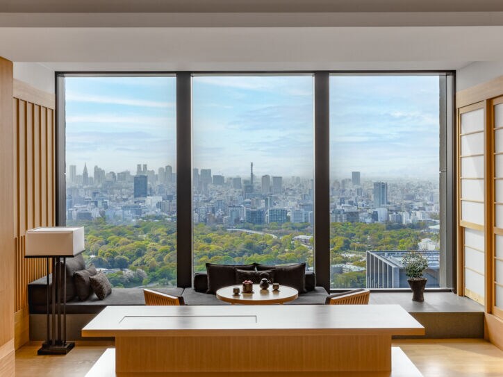 Hotelsuite im japanischen Stil mit Blick durch ein bodentiefes Panoramafenster auf die Skyline von Tokio