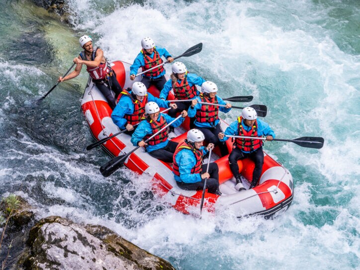 Acht Personen beim Wildwasser-Rafting in einem Schlauchboot