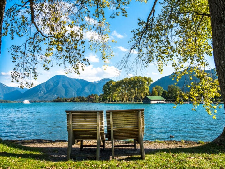 Zwei Holzliegen am Ufer des Tegernsees.