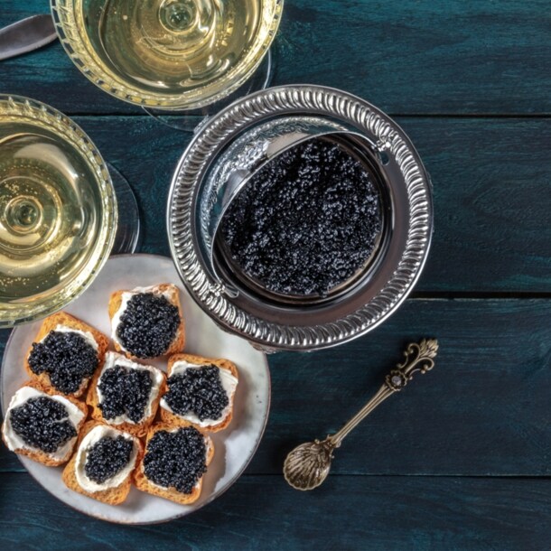 Sicht von oben auf eine Schüssel mit Kaviar und einen Teller mit Zwieback Creme und Kaviar