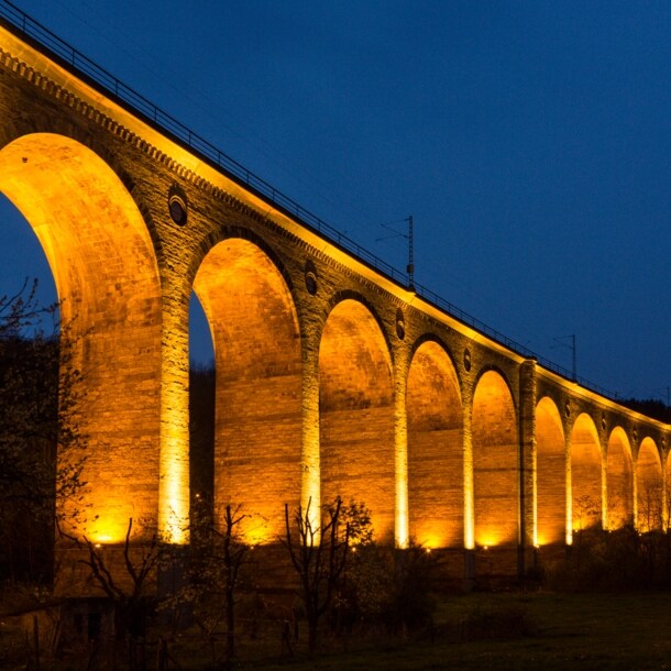 Hell beleuchtetes Viadukt bei Dunkelheit