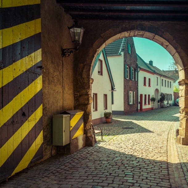 Ein historisches Stadttor mit gelb-schwarz gestreifter Tür