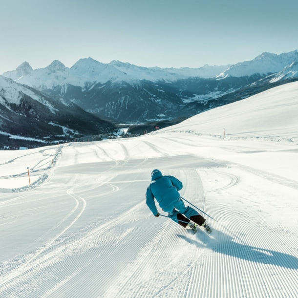 Eine Person fährt auf Skiern eine Abfahrt hinab.