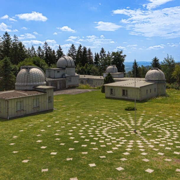 Gelände der Sternwarte Sonneberg, auf dem sich mehrere Gebäude mit Kuppeln befinden, daneben eine Installation mit Markierungssteinen, die sich kreisförmig am Boden um eine Stange anordnen